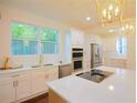 Bright kitchen boasts white cabinets, stainless steel appliances, quartz countertops, and a center island at 1454 Rome Nw Dr, Atlanta, GA 30314