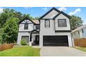 Two story home featuring a two-car garage, black trim, and manicured front lawn at 2111 Nelms Pointe Lndg, Lawrenceville, GA 30043