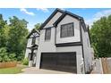 Two story home featuring a two-car garage, black trim, and manicured front lawn at 2111 Nelms Pointe Lndg, Lawrenceville, GA 30043