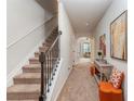 Inviting hallway features neutral tones, carpet, stairs, and decor, with an archway leading to the living space at 2149 Apple Orchard Way, Austell, GA 30168