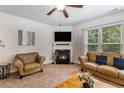 Cozy living room with a fireplace, plush seating, and a large window with outdoor views at 2149 Apple Orchard Way, Austell, GA 30168
