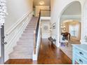Bright foyer featuring hardwood floors, a staircase, and a view into the dining room with a coffered ceiling at 2490 Tack Hill Ct, Dacula, GA 30019