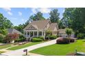 Attractive home featuring a welcoming front porch, well-maintained lawn, and a convenient driveway leading to the garage at 3902 Butterstream Way, Kennesaw, GA 30144