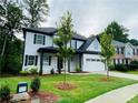 Inviting two-story home with a manicured front yard and classic black-and-white design at 1540 Ox Bridge Ct, Lawrenceville, GA 30043