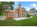 Brick home featuring a concrete patio, large yard, and mature trees at 110 Glen Eagle Way, Mcdonough, GA 30253