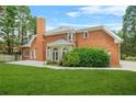 Large brick house with a chimney, a well-manicured lawn, and a patio at 110 Glen Eagle Way, Mcdonough, GA 30253