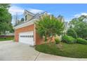 Side view of house with attached brick garage and driveway at 110 Glen Eagle Way, Mcdonough, GA 30253