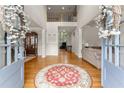 A grand entryway with hardwood floors, a high ceiling, decorative columns, and a view into the living spaces at 2100 Willshire Gln, Alpharetta, GA 30009