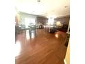 Large open kitchen with dark wood cabinets, an island with stools and hardwood flooring at 7625 Cedar Grove Ct, Fairburn, GA 30213