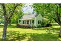 Exterior view displaying a charming home with a front porch, lush lawn, and mature trees at 1730 Lee Peters Rd, Loganville, GA 30052