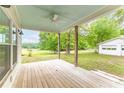 Covered rear porch with a ceiling fan, wood decking, and views of the backyard at 1730 Lee Peters Rd, Loganville, GA 30052