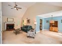 Open-concept living room featuring a fireplace, vaulted ceiling, and blue accent wall at 2715 Braemore Gln, Powder Springs, GA 30127