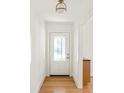 Bright foyer with a stained-glass front door, minimalist light fixture and wood flooring at 762 Rockbridge Nw Rd, Lilburn, GA 30047