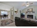 Open-concept living room features a fireplace, vaulted ceiling and view into the dining area at 1047 Taso Trl, Acworth, GA 30101