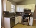 Well-equipped kitchen featuring stainless steel appliances, white cabinets, and granite counters at 5389 Martins Crossing Rd, Stone Mountain, GA 30088