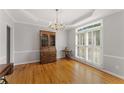 Elegant dining room with hardwood floors, chandelier, and decorative trim, with large windows for natural light at 2026 Cresthaven Walk, Woodstock, GA 30189
