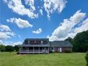 Charming red brick home with a covered porch, set on a spacious lawn under a sunny sky at 238 Marks Rd, Mansfield, GA 30055