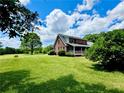 Beautiful brick home with a covered porch, nestled on lush green lawn with mature trees at 238 Marks Rd, Mansfield, GA 30055