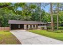 A cozy single-story home with lush greenery, a driveway, and a covered carport at 2771 Smithsonia Way, Tucker, GA 30084