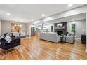 Open concept living and dining area with hardwood floors and a modern fireplace at 2771 Smithsonia Way, Tucker, GA 30084