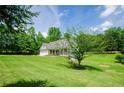 A spacious home sits on a well-manicured lawn with mature trees, creating a peaceful, private setting at 410 Hendon Rd, Woodstock, GA 30188