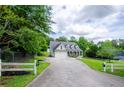 Long driveway leads up to a two-story home with an attached garage, surrounded by lush greenery and a white fence at 410 Hendon Rd, Woodstock, GA 30188