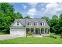 Inviting home features a cozy porch and a beautiful lawn, complete with a two-car garage at 410 Hendon Rd, Woodstock, GA 30188