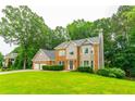 Beautiful two-story home featuring a three-car garage, brick facade, and large front yard at 3394 Floral Ct, Suwanee, GA 30024