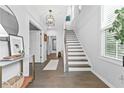 Bright foyer with a staircase, white walls, hardwood floors, and decorative accents at 6460 Cortland Walk, Alpharetta, GA 30005