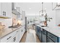 Stylish kitchen featuring white cabinets, stainless steel appliances, quartz countertops and large island at 6460 Cortland Walk, Alpharetta, GA 30005