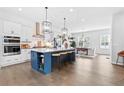 Modern kitchen with large island, white cabinets, stainless steel appliances and an adjacent dining area at 6460 Cortland Walk, Alpharetta, GA 30005