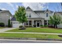 Charming two-story home with manicured lawn, inviting curb appeal, and attached two car garage at 1891 Primrose Park Rd, Sugar Hill, GA 30518