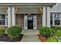 Welcoming front entrance with a black door, sidelights, brick accents, and well-maintained landscaping at 1891 Primrose Park Rd, Sugar Hill, GA 30518
