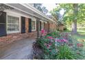 Welcoming front porch with decorative iron posts surrounded by lush flowerbeds with colorful roses at 2648 Oswood Dr, Tucker, GA 30084