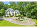 Elegant home showcasing a circular driveway, mature landscaping, and beautiful architectural details at 312 Crabapple Springs Way, Woodstock, GA 30188