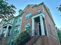 Two-story brick townhome featuring a charming entrance with wrought iron railing at 4875 Carre Way, Alpharetta, GA 30022