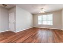 Bright living room with hardwood floors, ceiling fan, and a large window providing natural light at 112 Hawkeye Ln, Conyers, GA 30012