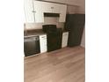 Kitchen featuring a black oven and fridge, white cabinets and wood-look flooring at 2751 Penwood Pl, Lithonia, GA 30058