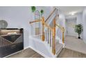 Bright entryway features hardwood floors, staircase, white railing, and modern light fixture at 541 Lantern Wood Dr, Scottdale, GA 30079