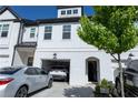 Charming townhouse with white brick and siding and attached garages at 82 Auburn Run Ln, Auburn, GA 30011