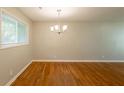 Bright dining room featuring gleaming hardwood floors, a modern chandelier, and a large window at 4345 Kimball Sw Rd, Atlanta, GA 30331
