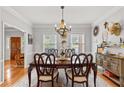 Elegant dining room with modern chandelier, hardwood floors, and wainscoting at 4648 Equestrian Way, Atlanta, GA 30338
