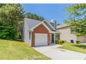 Lovely home with a well-maintained lawn, attached garage, and charming architectural details at 4695 Ravenwood Loop, Union City, GA 30291
