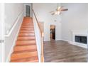 Bright living area with hardwood floors, fireplace, ceiling fan, and staircase at 4695 Ravenwood Loop, Union City, GA 30291