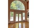 Sunlit living room with hardwood floors, soaring windows, and outdoor access is inviting at 4770 Powers Park Ne Ct, Marietta, GA 30067
