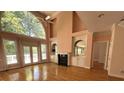 Sunlit living room with hardwood floors, fireplace, and a large arched window at 4770 Powers Park Ne Ct, Marietta, GA 30067