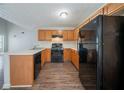 Efficient kitchen with light countertops, wooden cabinets, and modern black appliances, well-lit and functional at 6509 Charter Way, Lithonia, GA 30058