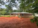 Rear exterior showcasing neutral siding, a small porch, and a spacious backyard ready for landscaping at 6668 Prinston Cir, Douglasville, GA 30135