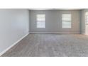 Bright living room featuring neutral paint, plush carpeting, and large windows for natural light at , Lithonia, GA 30038