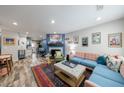 Open-concept living room with a fireplace, wood floors, and colorful furniture with eclectic art at 1915 Cooper Landing Se Dr, Smyrna, GA 30080